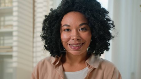 Photo for Close up portrait African American ethnic woman happy smiling girl beautiful millennial lady curly hairstyle female housewife homeowner at own home domestic living room looking at camera joyful smile - Royalty Free Image