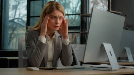Photo for Sick ill sad Caucasian middle-aged adult woman mature business lady businesswoman worker employer in office with computer suffer with headache pain ache painful head stress migraine pressure sickness - Royalty Free Image