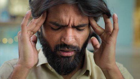 Téléchargez les photos : Arabe musulman malheureux barbu homme malsain homme d'affaires homme d'affaires stressant exécutif massages temples souffrent de maux de tête déprimé hispanique indien mâle souffrant de migraine douleur affaires difficiles - en image libre de droit