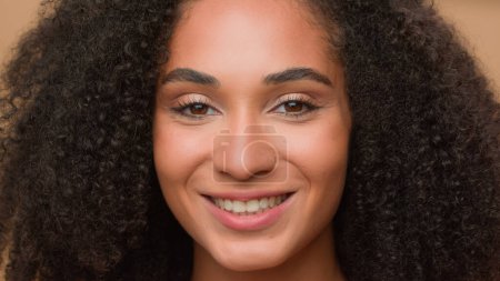 Téléchargez les photos : Gros plan femme parfait visage propre peau lisse maquillage souriant heureux afro-américain femme modèle fille belle dame sourire à la caméra posant en studio beauté soins de la peau headshot look to side - en image libre de droit