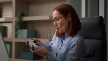 Photo for Funny female office worker addicted video game business woman playing console controller play online while nobody see girl businesswoman scared get caught hide joystick pretend working with computer - Royalty Free Image