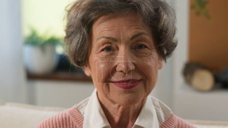 Headshot pensive grandmother senior woman looking distance away turn to camera old mature female elderly granny indoors at home smiling happy portrait older grey-haired healthy cheerful retired lady