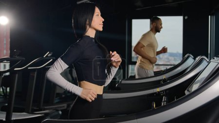 Photo for Sports people runners trainers running on treadmill in sport gym athletic man and woman run workout fit girl athlete sportswoman training cardio exercise run jogging in fitness club active lifestyle - Royalty Free Image