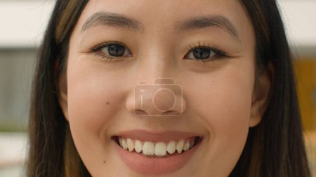 Foto de Close up face happy Asian woman smiling chinese korean japanese girl looking at camera head shot joyful lady with natural beauty make-up toothy smile client of cosmetology dental service healthcare - Imagen libre de derechos