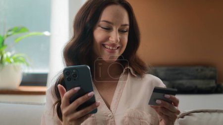Photo for Happy smiling client customer female buyer user Caucasian lady girl shopping with mobile phone bank app pay online buy goods order ecommerce from home woman make internet transaction with credit card - Royalty Free Image