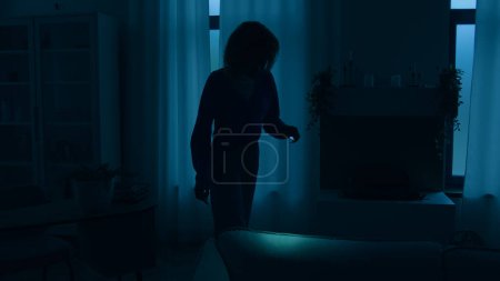 Photo for Woman girl lady female walking indoors in dark living room at night power war blackout electricity energy crisis outage searching lost things with flashlight at home without lights apartment darkness - Royalty Free Image