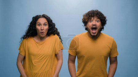 Photo for Amazed emotional shock wonder surprised excited happy shocked couple big eyes open mouth screaming yelling with amazement news diverse man woman achieve win victory achievement blue studio background - Royalty Free Image