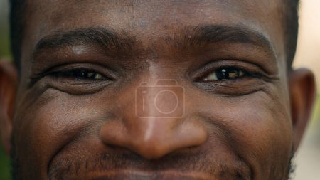 Téléchargez les photos : Cropped view close up male eyes Afro-Américain souriant heureux insouciant homme ethnique joyeux homme regardant les rides de la caméra expression joyeuse bonheur facial regarder bonne vision ophtalmologie - en image libre de droit