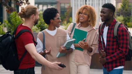 Photo for Multiracial students multiethnic friends African American women Caucasian men pupils university college campus outdoors talking after lesson studying make selfie photo with mobile phone shooting video - Royalty Free Image