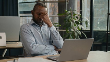 Photo for Exhausted sick mature senior businessman tired African American ethnic man office executive work on computer typing feel headache pain eyestrain fatigue health problem suffer migraine ache sit indoors - Royalty Free Image