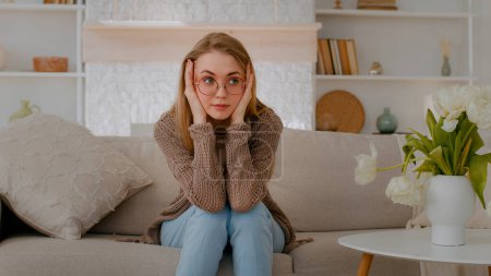 Photo for Tired exhausted fatigued stressed ill sick Caucasian woman girl lady at couch home sofa holding head problem thinking trouble solution migraine painful ache headache think upset unwell bad pain. High - Royalty Free Image