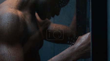 Foto de Cansado deprimido afroamericano desnudo poderoso hombre bajo el agua que cae en la ducha chico enojado golpeando la pared después del entrenamiento estrés impotencia ansiedad dolor pensar problema crisis lavado masculino cuidado corporal higiene - Imagen libre de derechos