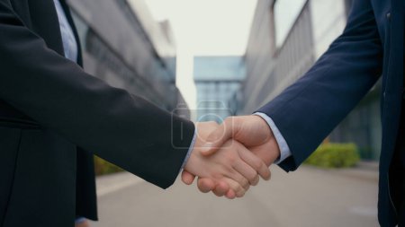 Photo for Formal greeting business handshake city outdoors urban office building close up hands man woman handshaking partnership agreement success deal female male shaking arms meeting cooperation partnership - Royalty Free Image