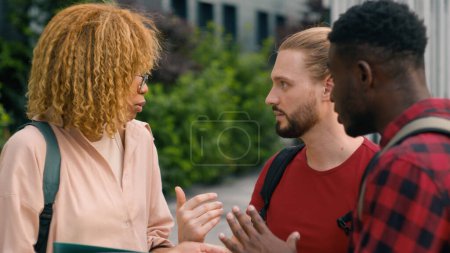 Photo for Happy diversity multiracial students diverse multiethnic friends two men and African American woman girl Caucasian guys outdoors university campus in city talking friendly conversation speaking talk - Royalty Free Image