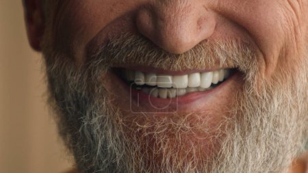Téléchargez les photos : Gros plan mâle blanc dents saines souriant vue recadrée heureux satisfait sourire gai positif méconnaissable vieil homme mûr avec barbe grise cheveux barbu grand-père prothèses dentaires médecine - en image libre de droit
