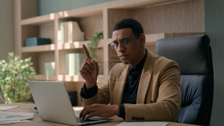 Photo for African American ethnic man serious businessman working online on laptop at office dissatisfied male investor business employer waving index finger negative position no answer not reject deny forbid - Royalty Free Image