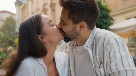 Photo for Boyfriend feeding girlfriend European couple lovers kissing sweet kiss love feelings relationship smile laugh Caucasian woman and man hugging eat in city cafe romantic date outdoors romance tenderness - Royalty Free Image