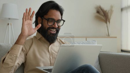 Photo for Arabian Indian muslim man talk at home video call conference on laptop freelance businessman speak distant negotiate smiling male teacher in glasses give online lecture remote education in quarantine - Royalty Free Image
