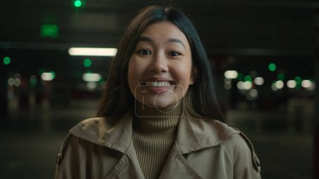 Foto de Primer plano retrato sonriendo feliz mujer asiático chino coreano chica étnico japonés estudiante mujer de negocios conductor señora de pie en el aparcamiento satisfecho dental sonrisa dentaria mirando cámara femenina disparo en la cabeza - Imagen libre de derechos