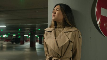 Téléchargez les photos : Asiatique peur ethnique chinois coréen femme se cachant de danger poursuite menace phobie dans souterrain abri nuit sombre parking peur fille craintive se tenir seul près d'arrêter de conduire panneau de signalisation routière - en image libre de droit