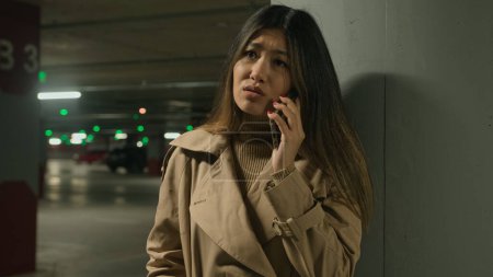 Photo for Anxious upset Asian woman chinese korean girl japanese businesswoman talk mobile phone outside car parking calling distant disappointed with smartphone conversation complain speak cellphone sadness - Royalty Free Image