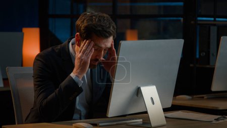 Photo for Exhausted Caucasian businessman adult man work overtime in office late night tired entrepreneur worried business problem make mistake failure difficulties with computer read bad news headache stress - Royalty Free Image