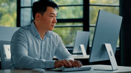 Téléchargez les photos : Concentré mature asiatique japonais coréen homme de bureau homme d'affaires professionnel entrepreneur travailler dans une entreprise développer un programme de jeu d'ordinateur navigation en ligne site web développement de la technologie - en image libre de droit