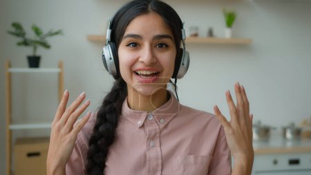 Téléchargez les photos : Webcam vue souriant Arabe fille dans les écouteurs heureuse ethnique indienne femme d'affaires étudiant parler à l'auditoire conférence par vidéoconférence en ligne webinaire de l'éducation à distance à domicile quarantaine - en image libre de droit