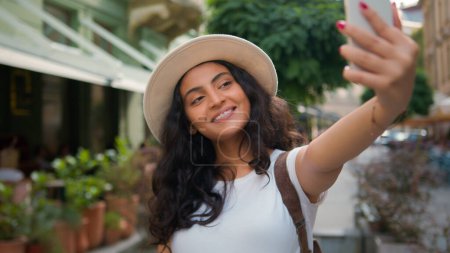 Téléchargez les photos : Happy souriant Indien Arabe ethnique femme fille étudiant touriste voyageur influenceur prendre selfie photo téléphone portable caméra ville à l'extérieur voyager vlog stream médias sociaux vidéo vacances - en image libre de droit