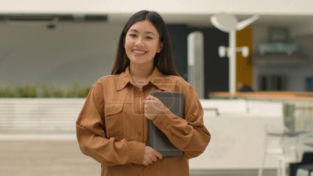 Foto de Empresaria coreana étnica china asiática en compañía de oficina posando con tableta digital. Retrato feliz mujer japonesa personal corporativo hr gerente de ventas mirando a la cámara sonriendo sonrisa dentada - Imagen libre de derechos