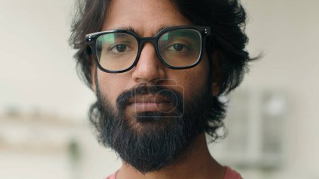 Téléchargez les photos : Gros plan arabe musulman barbu homme célibataire propriétaire indien multiethnique gars sérieux regardant caméra mauvais yeux vision dans les lunettes homme maison propriétaire locataire appartement ethnique adulte dans des lunettes - en image libre de droit