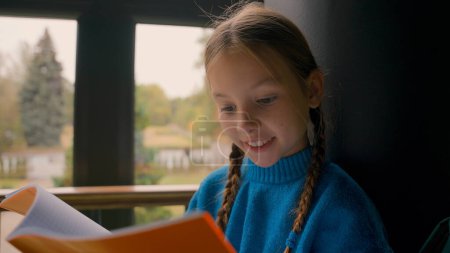 Photo for Little European amazed girl learner educational delighted school gymnasium surprised schoolgirl studying reading copybook open mouth shocked astonish interested inside pupil child preparing knowledge - Royalty Free Image