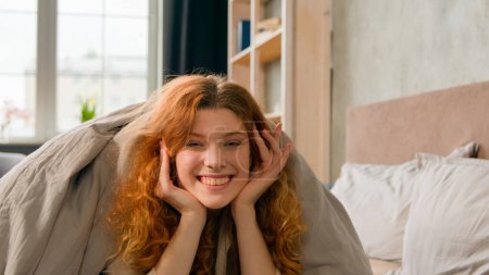 Photo for Cozy home bedroom attractive girl beautiful smiling happy kissing woman peeking out from under blanket hiding cover with duvet in bed kiss at camera laughing peep out appear playful laugh at morning - Royalty Free Image