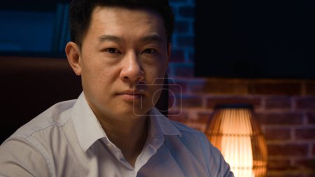 Photo for Serious Asian entrepreneur employer Korean businessman typing laptop working in Internet in office night evening adult calm Chinese man Japanese male manager computer work looking at camera portrait - Royalty Free Image