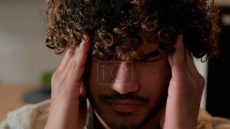 Nahaufnahme kranken müden arabischen männlichen Massagetempeln schmerzhaften Kopf Migräne Druck Kopfschmerzen in der heimischen Küche. Der Inder leidet unter Kopfschmerzen. Kranker erschöpfter Inder denkt an schwieriges Gesundheitsproblem