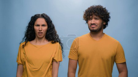 Photo for Indian Arabian ethnic couple man woman girl guy funny shock reaction in studio blue background cover nose bad smell suffer disgust stink suffering stinky smelly aroma frowning sniffing unpleasant odor - Royalty Free Image