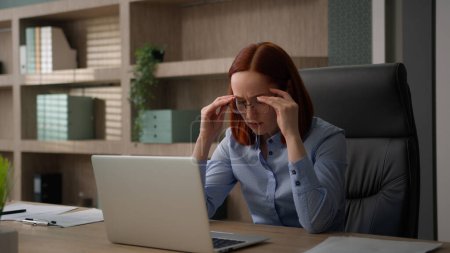 Photo for Caucasian businesswoman working with laptop in office tired of glasses woman eyestrain with computer work taking off spectacles massaging dry irritated eyes business girl exhausted eyesight problem - Royalty Free Image