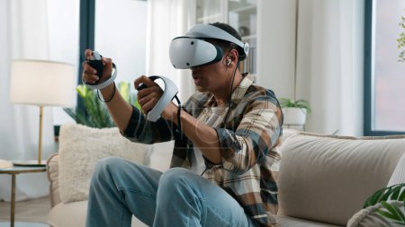 Photo for African American man player enjoying at home couch playing vr game fight boxing ethnic guy gamer male play online fighting wear headphones virtual reality 3d helmet glasses hold controllers joysticks - Royalty Free Image
