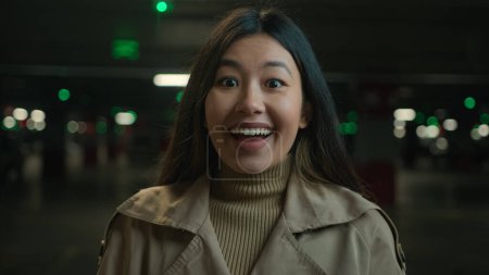 Téléchargez les photos : Fille excitée réaction étonnée visage surpris de la coréenne asiatique japonaise femme dans le parking heureux ethnique femme merveille wow choc surprise surprise rire bonnes nouvelles en regardant la caméra choquée - en image libre de droit