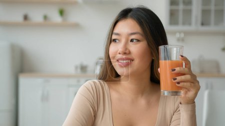 Chinesische Koreanerin trinkt Pfirsich Orangensaft zu Hause Küche träumen asiatische Mädchen trinken Glas fruchtigen Smoothie kalorienarmen frischen Vitamincocktail Gesundheit Körper Erfrischung Gewichtsverlust Entgiftung