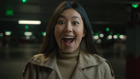 Porträt schockiert überrascht asiatische Frau chinesisch koreanisch japanisch glücklich ethnische Mädchen Wunder erstaunt weiblichen offenen Mund wow erstaunlich unerwartete Schock Überraschung glückliches Erstaunen Reaktion auf dunklen Parkplatz