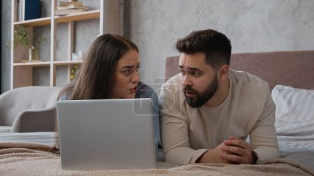 Photo for Caucasian upset couple husband wife worried shocked disappointed bad news loss negative result breakdown laptop internet service displeased woman girl and man guy in bedroom computer addicted failure - Royalty Free Image