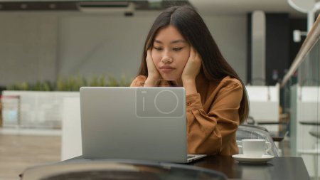 Photo for Exhausted overworked Asian woman girl student studying online work on laptop in office hold head headache tired chinese korean female employee businesswoman upset job failure despair fatigue burnout - Royalty Free Image
