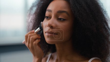 Photo for Beautiful girl female moisturized smooth healthy good skin tone applying powder blush make-up matte cosmetic prepare beauty skincare procedure pretty attractive African American woman powdering face - Royalty Free Image