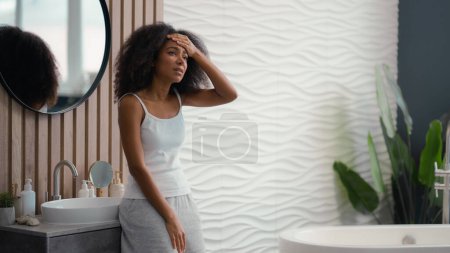 Afro-americano triste enferma chica birracial señora étnica mujer en baño sentirse mal malestar dolor de cabeza dolor de cabeza dolor doloroso síntoma problema de salud necesidad analgésico migraña resaca presión