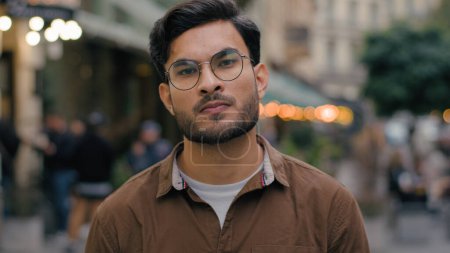 Close up portrait dissatisfied serious Indian Arabian ethnic male man student businessman guy looking at camera shaking head negatively disagree denial negative bad answer no outside city urban street