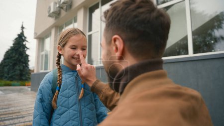 Photo for Father and daughter primary school farewell touch nose cute family joy happiness parenthood man girl schoolgirl study lessons gesture outside city kid child education pupil relations bond protecting - Royalty Free Image