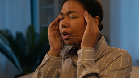 Kranke Afroamerikanerin benutzt Handy Gadget Süchtige in der Nacht zu Hause krank ungesund Mädchen auf der Couch fühlen Kopfschmerzen Migräne schmerzhafte Kopfkrämpfe massieren Schläfen leiden Schmerzen Bluthochdruck