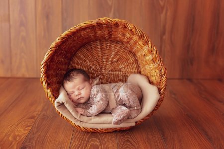 Téléchargez les photos : Mignon nouveau-né endormi dans un panier en bois sur fond en bois. Ferme là. Photo de haute qualité - en image libre de droit