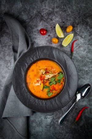 Photo for Tom yam soup with chicken, lime, cherry tomatoes and parsley - Royalty Free Image
